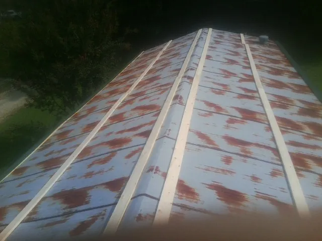 Rusted metal roof panels with new wood purlins before replacement — Storm Damage Roof Repair in Lyle by Roofing Brothers